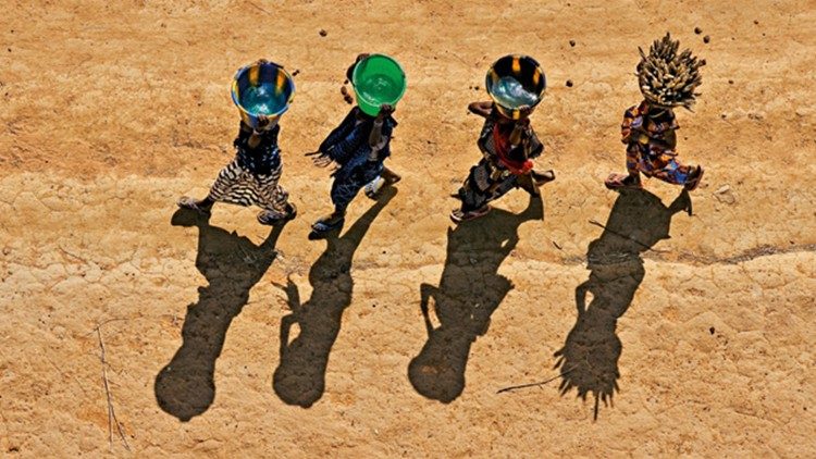 Des jeunes filles transportant de la nourriture et de l'eau dans les terres Dogon près de la falaise de Bandiagara, au Mali, en 2018.