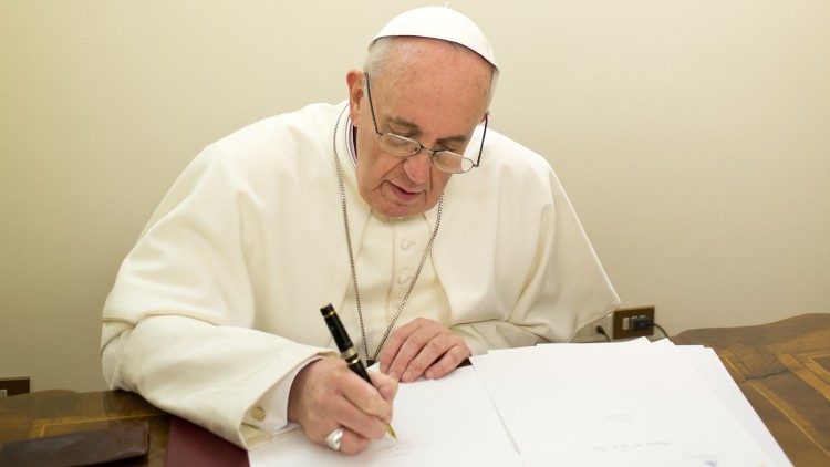 El Papa Francisco firma un documento, foto de archivo