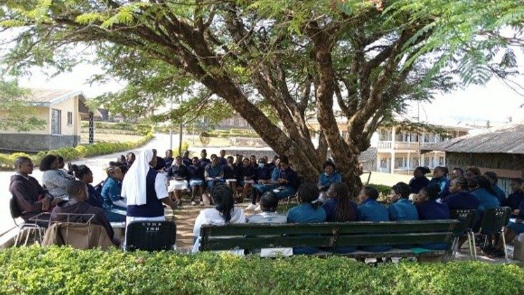 Students in prayer and reflection in nature in front of the Catholic School of Health Sciences