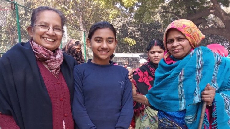 Sr. Shalini with two members of a family who stay in a temporary shed on the road