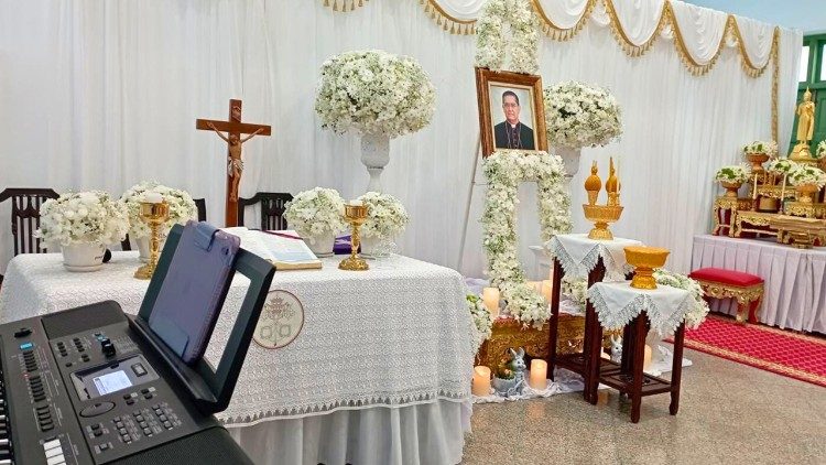 A solemn altar setup at Wat Phra Chetuphon Wimonmangklararm Ratchaworamahawihan in Bangkok, featuring a portrait of Cardinal Miguel Ángel Ayuso Guixot, a crucifix, and traditional Buddhist offerings. Photo by Sr. Kannikar Iamtaisong