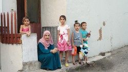 A mother and children pose outside a typical residence at Dbayeh refugee camp, north of Beirut. Photo: