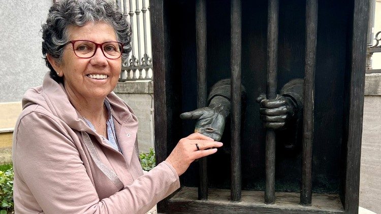 La hermana Nelly toca las heridas del Cristo encarcelado en una escultura de Timothy Schmaltz.